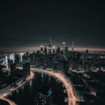 An impressive view of skyscrapers against the night sky, their windows aglow with lights, capturing the essence of the urban night.