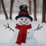 Building a snowman with a red scarf, highlighting a joyful winter activity perfect for families.