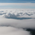 Embark on a snowy mountain adventure with a towering peak emerging majestically above the clouds, inviting exploration.