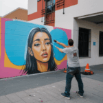 A street artist painting a vibrant mural on an urban wall, showcasing colorful creativity.