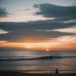 A stunning sunset over a calm ocean with vibrant colors reflecting on the water, capturing a serene and peaceful moment in nature's beauty.