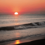 A serene sunset at sea, with the horizon glowing in warm, vibrant hues.