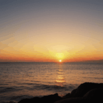 The serene beauty of a sunset over a calm ocean, with vibrant sky colors.