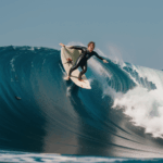 A high-energy moment of surfing on a colossal wave, emphasizing the excitement of the sport.