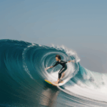 A surfer skillfully riding a huge wave, demonstrating mastery and passion for the sport.