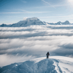 Towering mountain peaks with snow-covered summits set against a backdrop of clouds, creating a picturesque and serene vista.