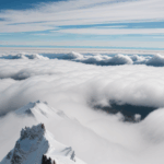 Unforgettable mountain experience with a snow-capped peak standing tall above the clouds, showcasing nature's splendor.
