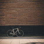 An urban cycling scene with a bicycle resting on a textured brick wall, capturing the essence of city life.