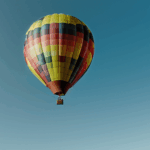 An awe-inspiring view of a colorful hot air balloon ascending into the sky, symbolizing freedom and adventure.
