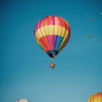 Multiple colorful hot air balloons creating a stunning pattern against the sky.