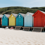 A vibrant shore with colorful beach huts under a clear blue sky