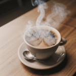 A cozy scene with a steaming cup of coffee on a wooden background.