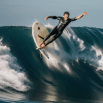 A fearless surfer conquering a giant wave, showcasing determination and surfing expertise.