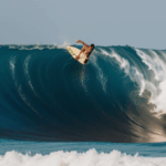 An immersive experience of surfing a huge wave, capturing the thrill and adventure of the ocean.