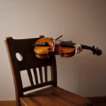 Serene scene with a violin placed on a wooden chair, evoking musical passion.